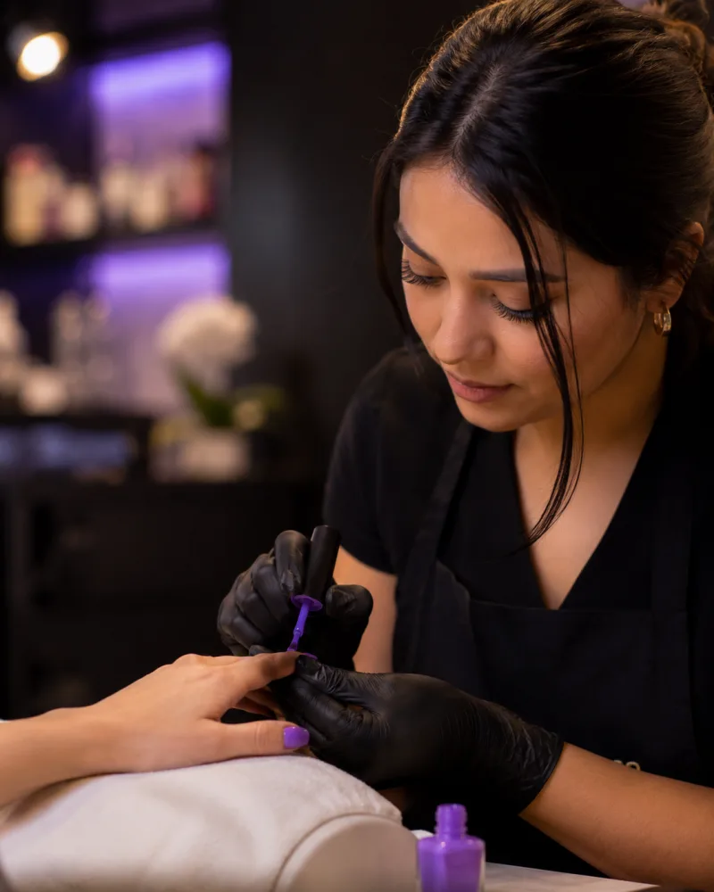 Manicurista haciendo un manicure en su salón